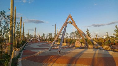 Toronto, ON, Kanada - 13 Ekim 2025: Toronto 'daki Biidaasige Park' ta ahşap yapıları olan bir şehir parkı ve insanlar renkli bir günbatımının keyfini çıkarıyorlar..