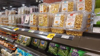 Montreal, QC, Kanada - 1 Ağustos 2025: Çeşitli gıda ürünleriyle dolu raflarla dolu bir markette geniş ve parlak bir koridor aşağı doğru bir manzara.