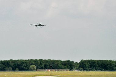 İstanbul, Türkiye - 9 Ağustos 2008: İniş takımlı yolcu uçağı bulutlu bir günde varışa hazırlanmak üzere bir havaalanı pistine iniyor
