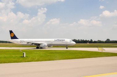 İstanbul, Türkiye - 9 Ağustos 2008: Lufthansa Airbus A321, bulutlu, kalkış ve ticari uçuşlara hazır, açık mavi gökyüzü altında havaalanında piste çıkıyor
