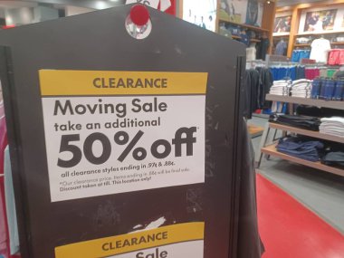 Toronto, ON, Kanada - 8 Haziran 2025: Bir perakende mağazasında% 50 indirim sunan giyim mağazasında belirgin bir şekilde sarı ve siyah 'Temiz Taşıma' tabelası sergileniyor