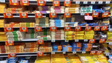 Toronto, ON, Kanada - 6 Aralık 2025: Bir süpermarkette peynir, yoğurt ve diğer dondurulmuş gıdalar dahil olmak üzere çeşitli süt ürünleri ile dolu uzun bir buzdolabı...