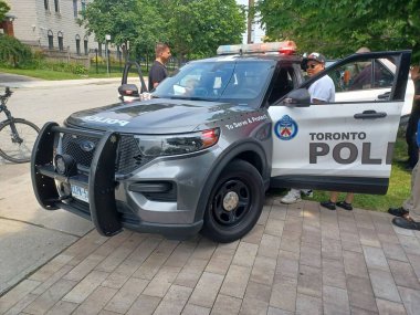 Toronto, ON, Kanada - 25 Eylül 2025: Gri beyaz bir Toronto polis arabası kamu etkinliği sırasında kapısı açık park halinde..