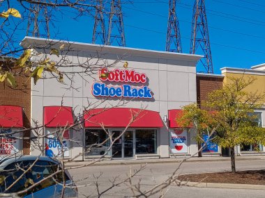 Toronto, ON, Kanada - 19 Eylül 2025: Güneşli bir günde kırmızı tenteli ve binanın önünde park yeri olan SoftMoc Shoe Rack mağazası.