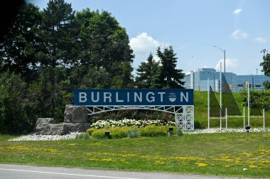 Toronto, ON, Kanada - 30 Ağustos 2025: Burlington, Ontario şehri için bir karşılama tabelası yolun yanındaki çimenli bir tepenin üzerinde duruyor.