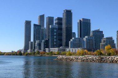 Günümüzde Ontario Gölü boyunca yerleşim ve ticari kuleleri bulunan Etobikola silueti, güneşli bir günde canlı sonbahar yeşillikleri ve açık mavi gökyüzü