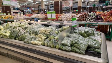 Toronto, ON, Kanada - 25 Kasım 2025: Taze yeşil yapraklı sebzeler paketlenir ve T ve T ve T Asya süpermarketlerinin üretim bölümünde soğutulmuş bir kutuda sergilenir.