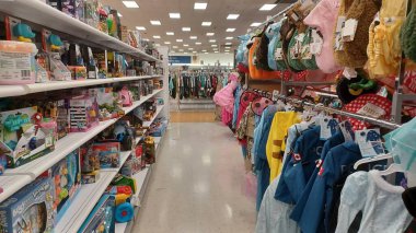 Toronto, ON, Kanada - 13 Ekim 2025: Renkli çocuk kıyafetlerinin rafları parlak aydınlatılmış bir perakende mağazasında sergileniyor.