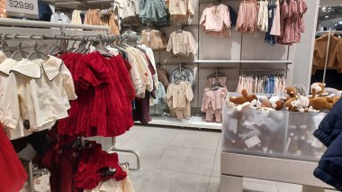 Toronto, ON, Kanada - 23 Kasım 2025: Modern bir perakende mağazasının içi müşterilerin bakmaları için raflarda ve raflarda çeşitli giyim ürünleri sergiliyor.