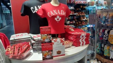 Toronto, Kanada - 9 Ekim 2025: Kırmızı Kanada tişörtleri, akçaağaç kahvesi, waffle ısırıkları ve Kanada sembollü renkli çoraplar içeren hediyelik eşya dükkanı