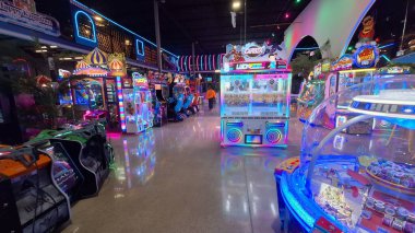 Toronto, ON, Kanada - 3 Şubat 2026: Geniş bir aile macera parkı Mutlu Krallık içindeki çeşitli atari makinelerini ve eğlence merkezlerini aydınlatan renkli neon ışıklar.