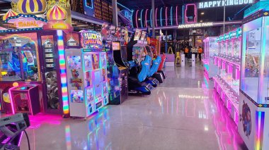 Toronto, ON, Kanada - 3 Şubat 2026: Geniş bir aile macera parkı Mutlu Krallık içindeki çeşitli atari makinelerini ve eğlence merkezlerini aydınlatan renkli neon ışıklar.