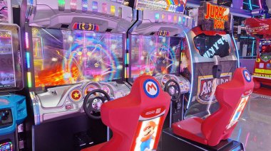 Toronto, ON, Kanada - 3 Şubat 2026: Geniş bir aile macera parkı Mutlu Krallık içindeki çeşitli atari makinelerini ve eğlence merkezlerini aydınlatan renkli neon ışıklar.