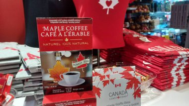 Toronto, Kanada - 9 Ekim 2025: Kırmızı Kanada tişörtleri, akçaağaç kahvesi, waffle ısırıkları ve Kanada sembollü renkli çoraplar içeren hediyelik eşya dükkanı
