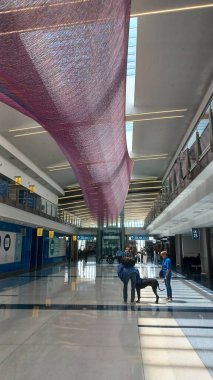 Charlotte, NC, ABD - 9 Haziran 2025: Bu Charlotte Havalimanı 'nda sanatın yanından geçen insanların yoğun bir ulaşım merkezi oluşturduğunu gösteriyor..