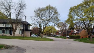 Toronto, ON, Kanada - 26 Nisan 2025 Bulutlu bir günde ilk bahar çiçeklerini gösteren Etobicolu yerleşim yeri caddesi.
