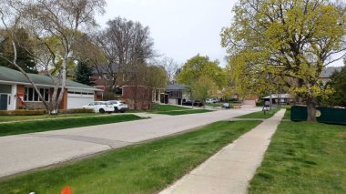 Toronto, ON, Kanada - 26 Nisan 2025: Bu fotoğraf bir bahar günü evleri, ağaçları, çimenleri ve arabaları olan bir Etobikola caddesini gösteriyor.