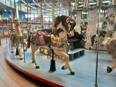 Toronto, ON, Kanada - 26 Şubat 2026: Atlı karınca, kapalı bir lunapark ortamında süslemeler, boyanmış atlar sergiliyor ve nostaljik bir sahne yaratıyor.