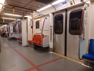 Toronto, ON, Kanada - 6 Eylül 2025: Modern bir metro vagonunun içi kırmızı koltuklar ve istasyonlar arasında seyahat eden birkaç yolcu gösteriyor.