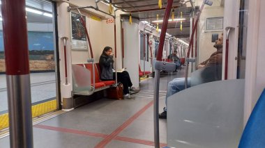 Toronto, ON, Kanada - 6 Eylül 2025: Modern bir metro vagonunun içi kırmızı koltuklar ve istasyonlar arasında seyahat eden birkaç yolcu gösteriyor.