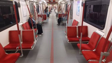 Toronto, ON, Kanada - 6 Eylül 2025: Modern bir metro vagonunun içi kırmızı koltuklar ve istasyonlar arasında seyahat eden birkaç yolcu gösteriyor.