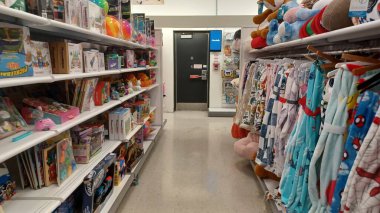 Toronto, ON, Kanada - 13 Ekim 2025: Renkli çocuk kıyafetlerinin rafları parlak aydınlatılmış bir perakende mağazasında sergileniyor.