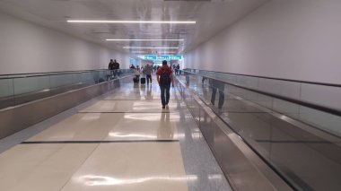 Charlotte, NC, ABD, 10 Ekim 2025: Bagajlı insanlar Charlotte Douglas Uluslararası Havalimanı 'nda parlak ve ferah bir salonda yürüyorlar