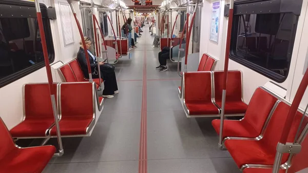 Toronto, ON, Kanada - 6 Eylül 2025: Modern bir metro vagonunun içi kırmızı koltuklar ve istasyonlar arasında seyahat eden birkaç yolcu gösteriyor.