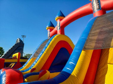 Toronto, ON, Kanada 31 Mayıs 2024: Aileler güneşli bir öğleden sonra bir çocuk etkinliğinde büyük şişme slaytlar ve engelli parkurların etrafında toplandılar..