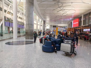 Toronto, ON, Kanada - 23 Ekim 2025: Toronto Pearson Havaalanı 'ndaki 1 numaralı terminalin içi, bekleyen, yürüyen ve rahatlatan insanları gösteriyor.
