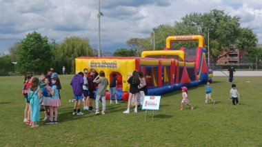 Toronto, ON, Kanada - 9 Eylül 2025: Çocuklar şişme engelli parkurunda oynuyorlar. Park Lawn 'da güneşli, aydınlık bir gün..