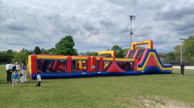 Toronto, ON, Kanada - 9 Eylül 2025: Zıplayan şato çimlerin üzerinde duruyor, yaz boyunca eğlenceli aktiviteler vaat ediyor.