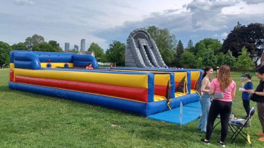 Toronto, ON, Kanada - 9 Eylül 2025: Şişme engelli parkuru yeşil çimenlerdeki bir açık hava etkinliğinde çocuklar için eğlence sağlıyor.