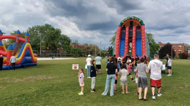 Toronto, ON, Kanada - 9 Eylül 2025: Bir günlük eğlence için şişme şatoların yer aldığı bir açık hava etkinliğinde bir kalabalık toplandı.