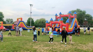 Toronto, ON, Kanada - 9 Eylül 2025: İnsanlar mutlu ve canlı bir aile etkinliğini temsil eden parktaki şişme kalelerden hoşlanırlar.