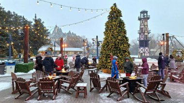 Harikalar Diyarı, Kanada - 31 Aralık 2025: İnsanlar kış festivalinin tadını çıkararak, karların arasında büyük bir Noel ağacı ile sıcak bir atmosfer yarattılar..