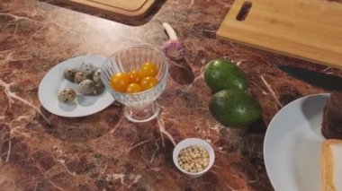 Sarımsaklı salata, bıldırcın yumurtası, domates, karides, zeytinyağı soslu, avokado. Mutfak tezgahında basit bir Lezzetli Yemek Hazırlama. Mutfak masasındaki sebzeler. Sağlıklı Organik Gıda.