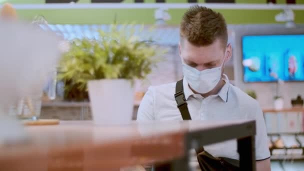 一个戴防护口罩的男人在超市里选择食物 进行社会疏离 戴口罩以防止传染病爆发的人 — 图库视频影像