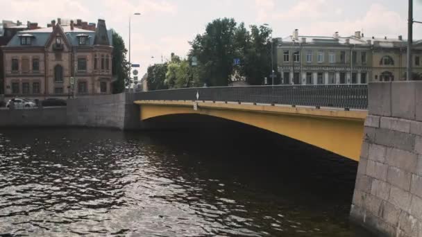 河上的黄桥 有车可以走 小波浪在流经城市的沟渠中喷涌而出 这条河的水深很深 所以很暗 水面波动 — 图库视频影像