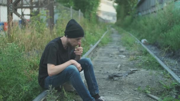 Vagabundo Fumando Cigarrillo Sopla Humo Sentado Ferrocarril Descompuesto Sumido Pobreza — Vídeos de Stock