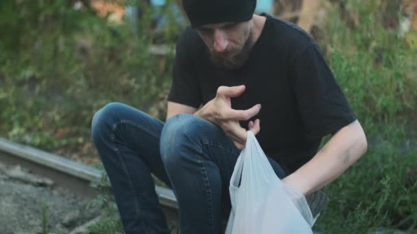 一个无家可归的男人带着他的东西试图在包里找到一些东西 崩溃的人 陷入贫穷 被解雇 被解雇 被烧毁 社会问题 失业概念 — 图库视频影像