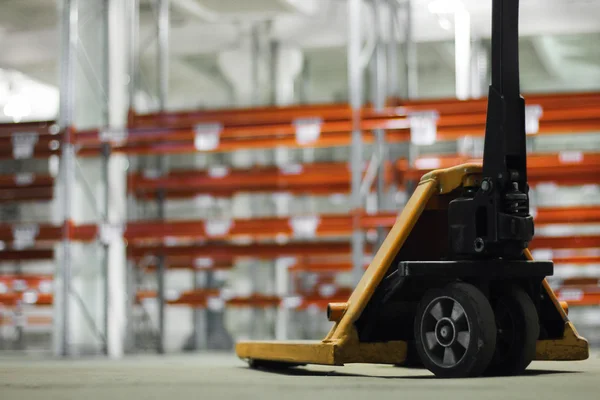 Manual hydraulic lift against the light warehouse — Stock Photo, Image