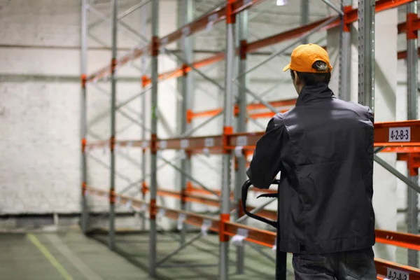 Trabajador que transporta un elevador hidráulico manual —  Fotos de Stock