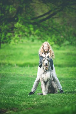 uzun hafif saçlı kız sarılmak büyük bir gri köpek