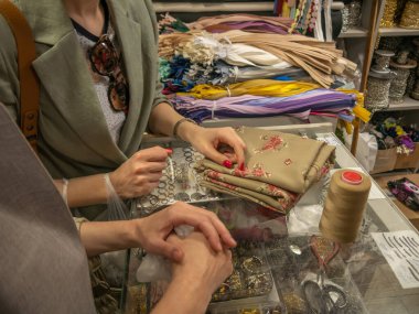 İki kadının ellerinin yakın çekimi kumaşın rengini seçer..