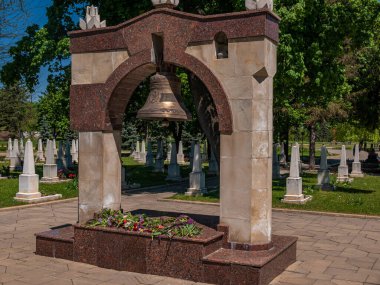 Hristiyan askeri mezarlığında kemerin altında büyük bir bronz çan..