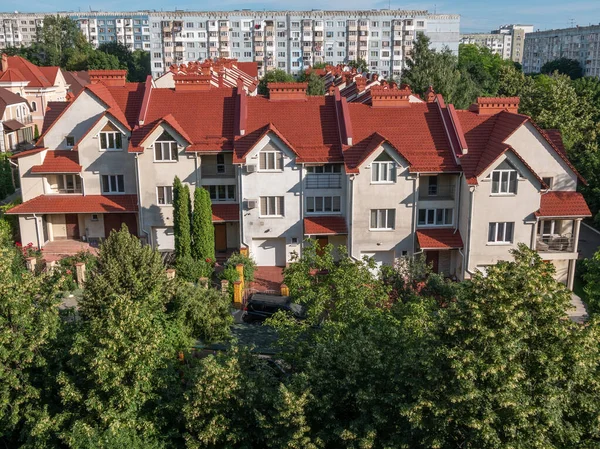 高層都市の建物の中にモダンな3階建てのコテージ村 ファサードの側面からの眺め — ストック写真