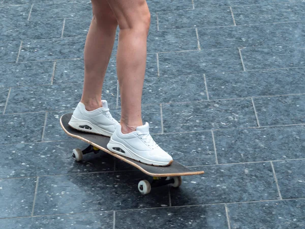 Uzun Tahta Üzerinde Beyaz Spor Ayakkabılı Kadın Bacaklarının Yakın Çekimi — Stok fotoğraf