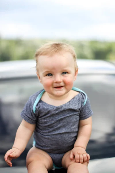 Little happy smiling cute newborn baby sitting in nature — Stock Photo, Image