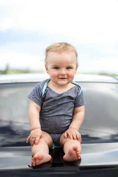 Pouco feliz sorrindo bebê recém-nascido bonito sentado na natureza — Fotografia de Stock